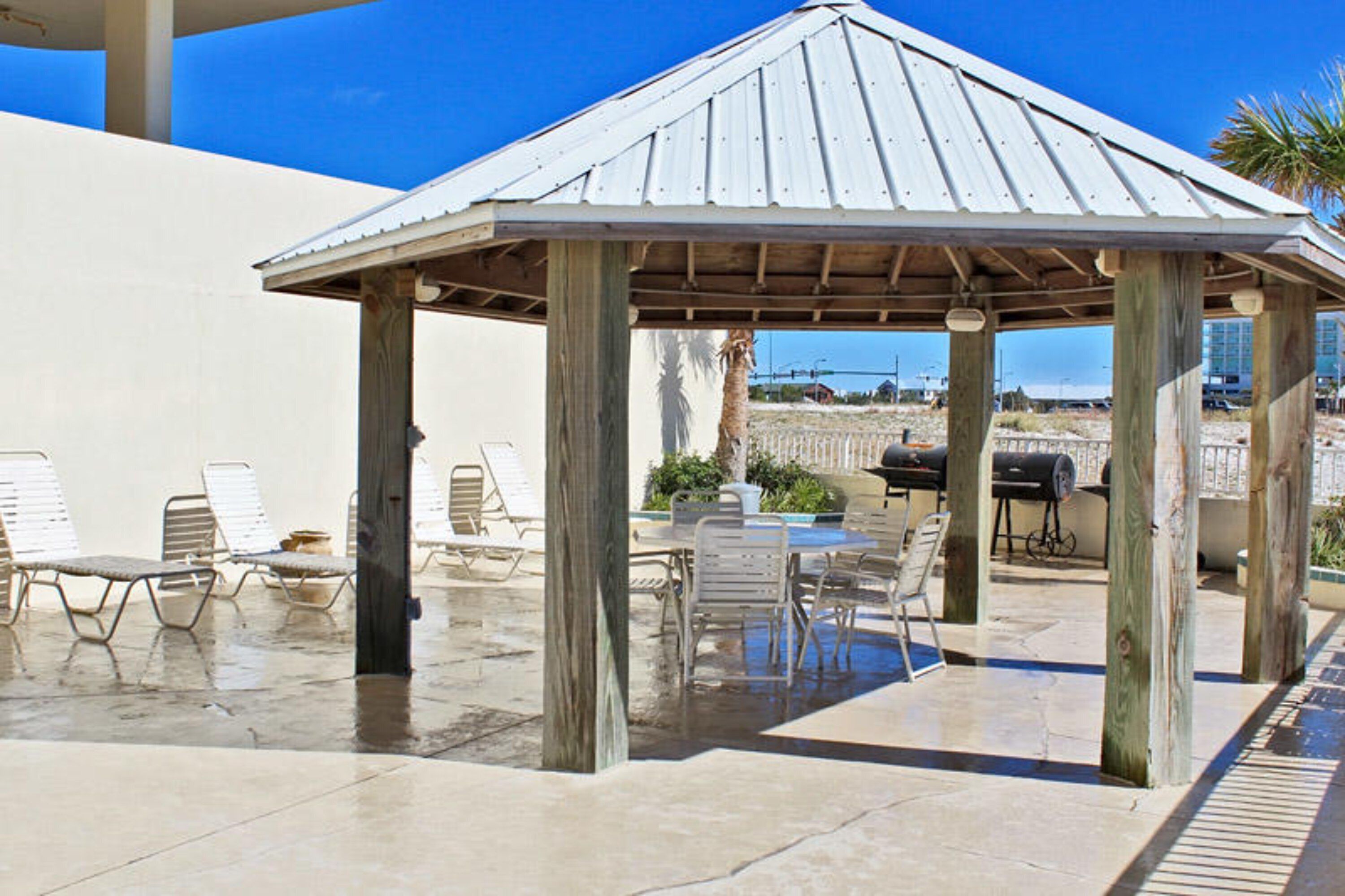 Un espace extérieur abrité, aménagé avec des fauteuils confortables et un barbecue.
