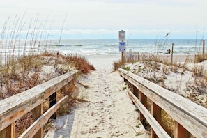 A wooden boardwalk leading to the beach with a signpost in the distance. - Seascape 102 by Youngs Suncoast (Orange Beach)