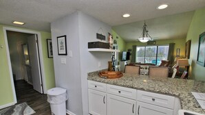 A kitchen with white cabinets, granite countertops, and a built-in oven. - Palmetto 306 (Orange Beach)