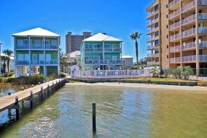 A waterfront hotel with a dock, multiple balconies, and a view of the water. - On Golden Pond 8A West (Gulf Shores)