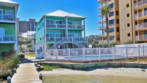 A multi-story hotel with a pool area, a wooden deck, and a beach view. - On Golden Pond 8A West (Gulf Shores)