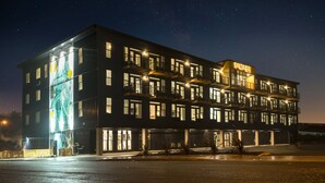 Un hôtel à plusieurs étages, doté d’un design moderne, de balcons et de grandes fenêtres.