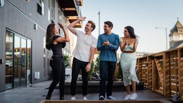 Un grupo de personas sobre una plataforma de madera, con un edificio al fondo.