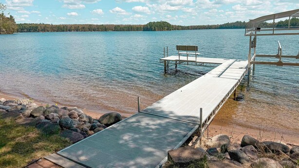 A lakeside dock with a bench and a covered seating area. - Katherine Lake Lodge (Hazelhurst)
