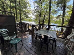 A wooden deck with a table and chairs, overlooking a body of water. - Minocqua Shores Condo #7 (Minocqua)