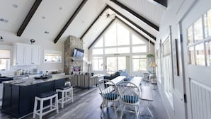 A spacious kitchen with a large island, dark wooden flooring, and a stone fireplace. - Exquisite Cottage on Lake Brophy. Lic1971 (Alexandria)