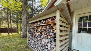 A wooden shed with a stack of firewood.