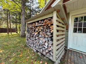 A wooden shed with a stack of firewood.