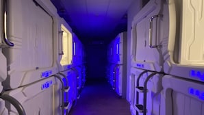 Corredor com beliches em um quarto com pouca luz.