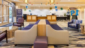 A hotel lobby with a reception desk, seating area, and a VIP lounge sign.