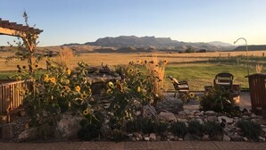 Ein Patio mit Pergola, einer Bank und einem Feuerkorb.