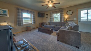 Ein Wohnzimmer mit einer Couch, einem Couchtisch, einem Kamin und einem Deckenventilator.