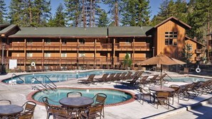 A resort with a pool area, multiple balconies, and a wooden building structure.