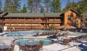 A resort with a pool area, multiple balconies, and a wooden building structure.