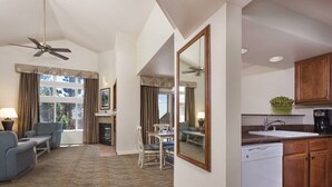 Una habitación de hotel con sala de estar, comedor y cocina.