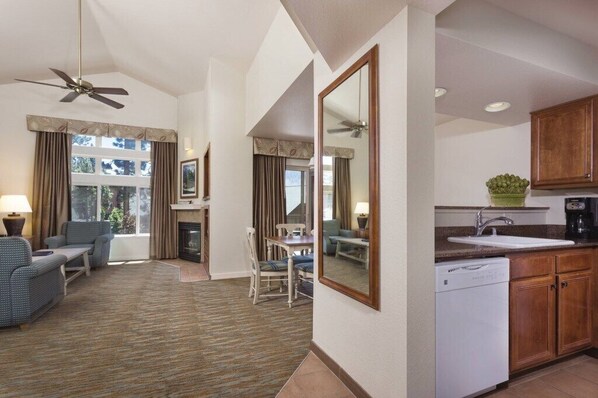 Una habitación de hotel con sala de estar, comedor y cocina.