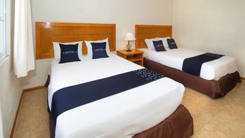 Two double beds with wooden headboards, white bedding, and dark blue bed runners.