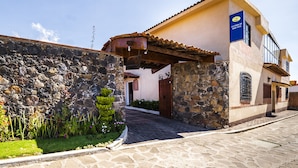 A stone wall with a gate, a paved entrance, and a building with a sign reading "La Casa de Don Tito". - Hotel La Casa de Don Tito, Jocotitlán (Jocotitlán)