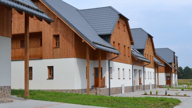 Une rangée de bâtiments en bois, avec une base en pierre, qui font probablement partie d’un hôtel ou d’un complexe touristique.