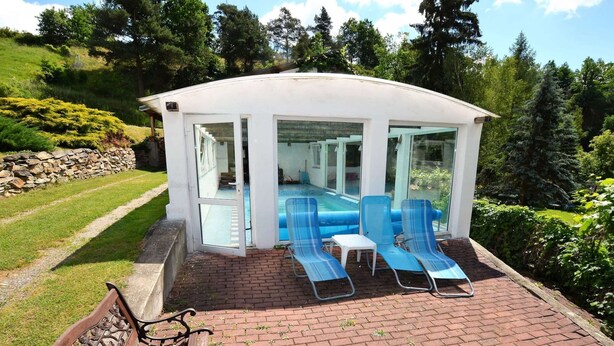 A covered outdoor pool area with two lounge chairs and a small table. - South Bohemia Family Escape (Bechyne)