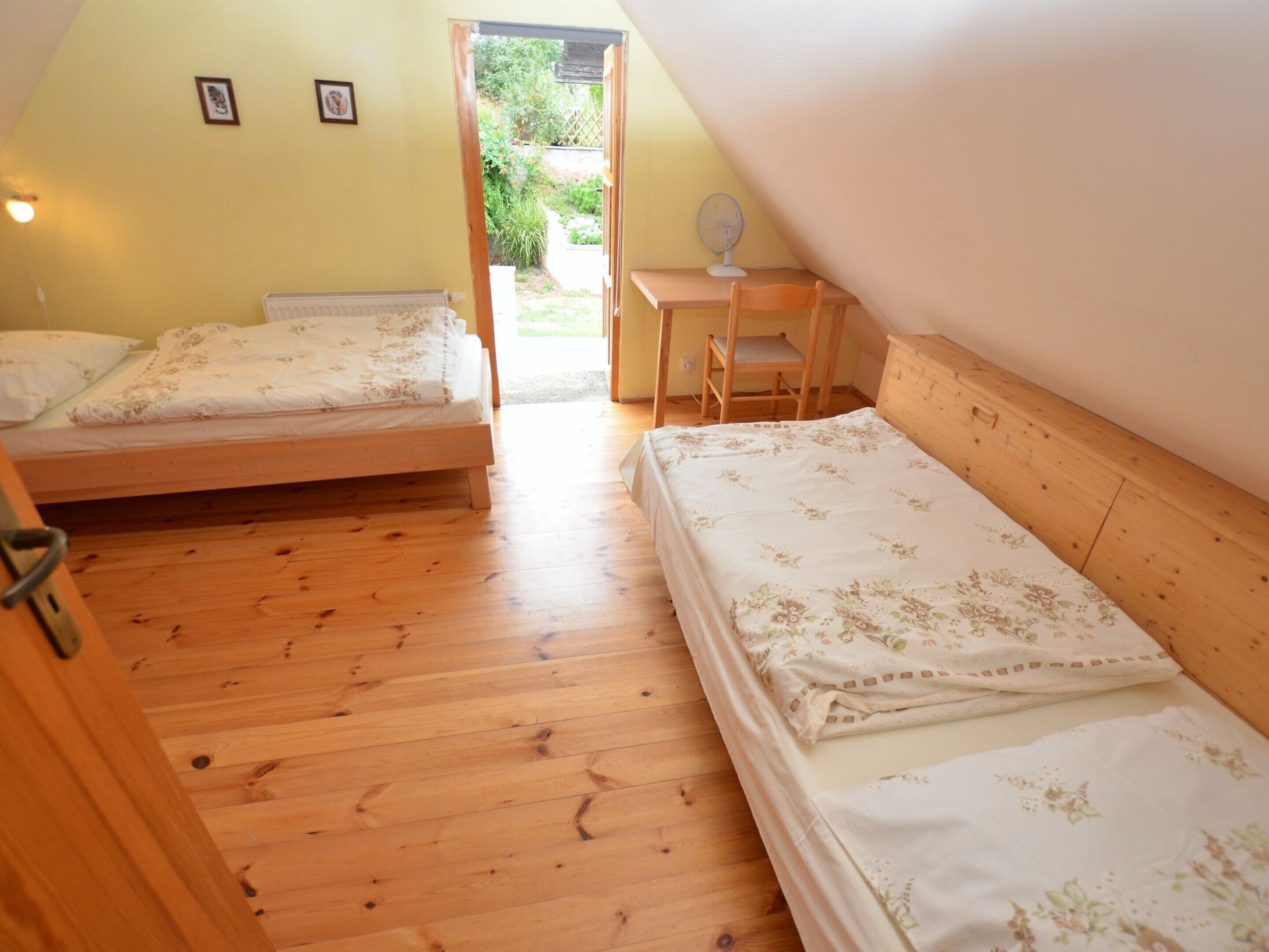 Ein Schlafzimmer mit zwei Holzbettgestellen, einem Schreibtisch und einem Stuhl.