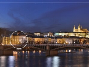 A nighttime view of a cityscape with a prominent castle and a bridge over a river. - Charming Prague Downtown Flat (Prague)