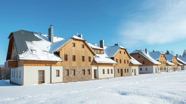 A row of wooden houses with snow-covered roofs and a clear blue sky. - Comfortable Apartment With Balcony, Storage and Parking (Nova Pec)