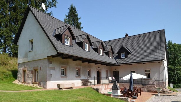 A large, two-story building with a sloped roof, stone exterior, and multiple windows. - Apartment in Bohemian With Shared Pool (Vidochov)