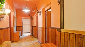 A hallway with wooden paneling, a bench, and antler decorations. - Lavish Cottage near Ski Area in Cerny Dul (Cerny Dul)