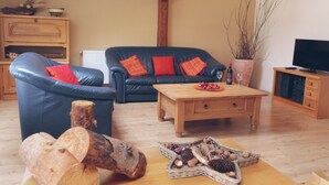 A living room with a blue sofa, wooden coffee table, and a TV stand.
