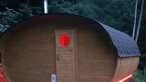A wooden cabin with a curved roof, a door with a red octagonal window, and a no-smoking sign. - Elite Cottage in Turnov near Ski Area (Turnov)