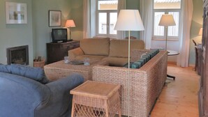 A cozy living room with a sofa, a small table, and a television. - Holiday Home Milire Bohemian Forest (Milire)