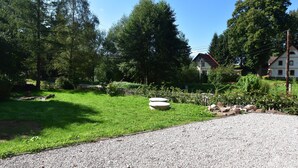 A residential area with a well-maintained lawn, a gravel path, and a house with a red roof. - Holiday Home Rudnik Near Ski Lift (Rudník)