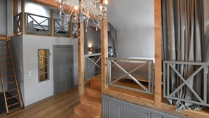 A multi-level interior with a staircase, wooden beams, and a chandelier. - Apartment in Detershagen With Terrace (Kroepelin)