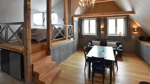 A spacious loft with a dining area, kitchen, and sleeping loft bed. - Apartment in Detershagen With Terrace (Kroepelin)