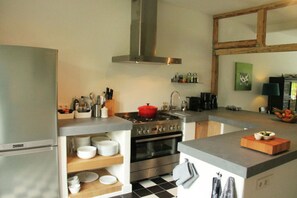 Kitchen features a stainless steel range hood, oven, and sink with a countertop.