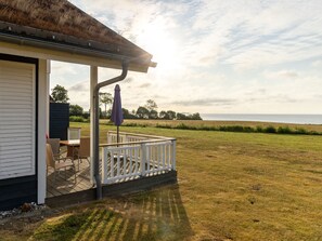 A covered outdoor seating area with a view of the sea. - Bungalow by the Sea With Sauna in Germany (Sierksdorf)