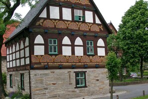 Traditional half-timbered house with a symmetrical facade and evenly spaced windows.