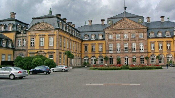 Ein historisches Gebäude mit klassischer Architektur, gekennzeichnet durch symmetrische Fenster und einen zentralen Eingang.