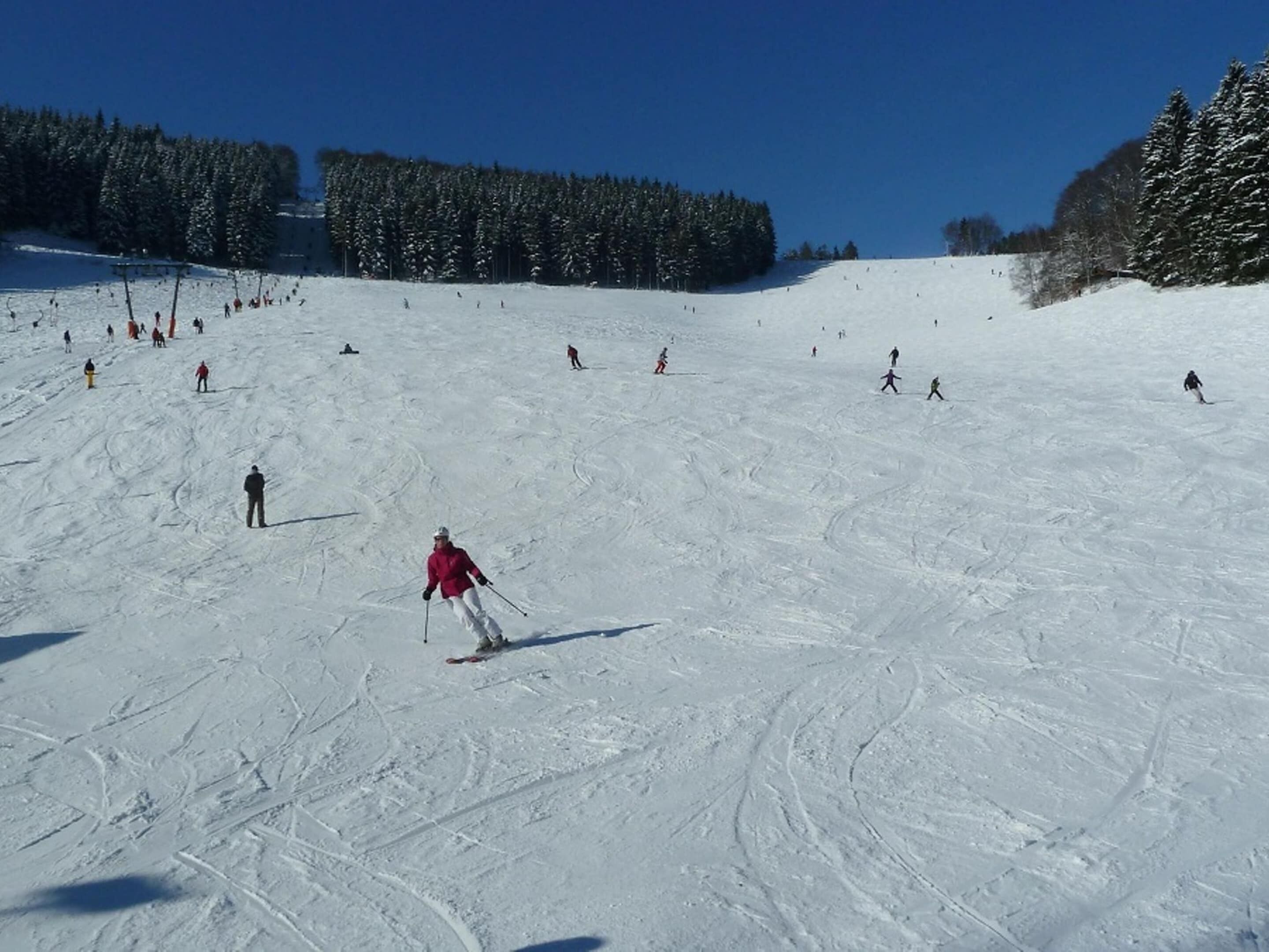 Une piste de ski avec des skieurs et des snowboardeurs.