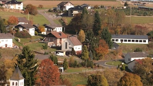 A residential area with houses, a church, and a solar panel building.