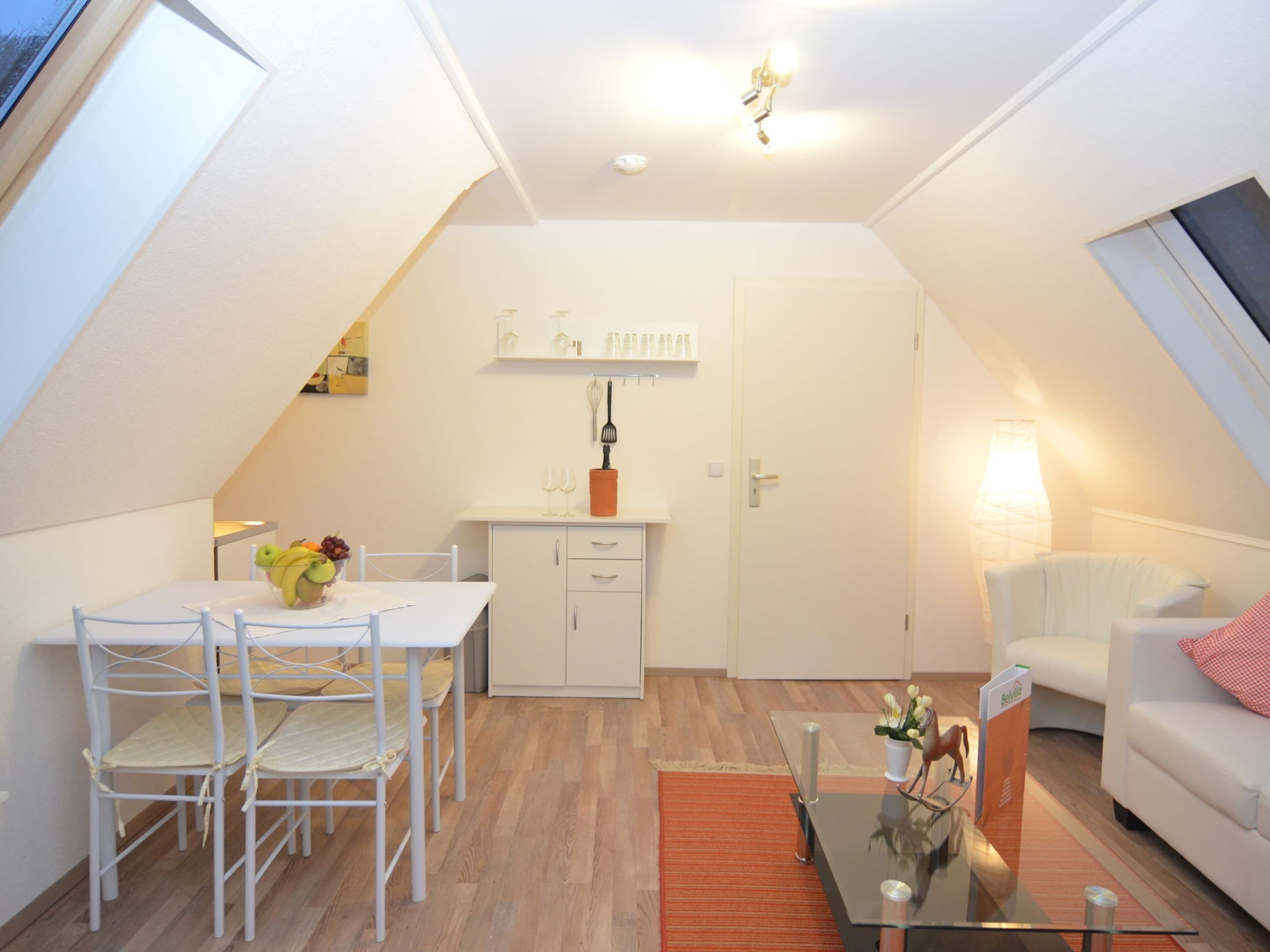 A compact living space with a dining area, kitchenette, and seating area.