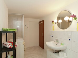 Une salle de bain équipée d’un lavabo, d’un miroir et d’un porte-serviettes.