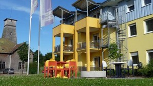 A yellow multi-story building with balconies and a spiral staircase. - Apartment in Bad Durrheim Near Lake Constance (Bad Duerrheim)