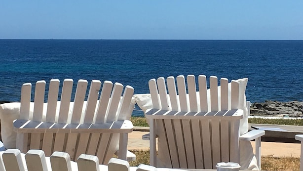 Two white Adirondack chairs facing a view of the ocean. - Belvilla by OYO Mil Flores (Benissa)