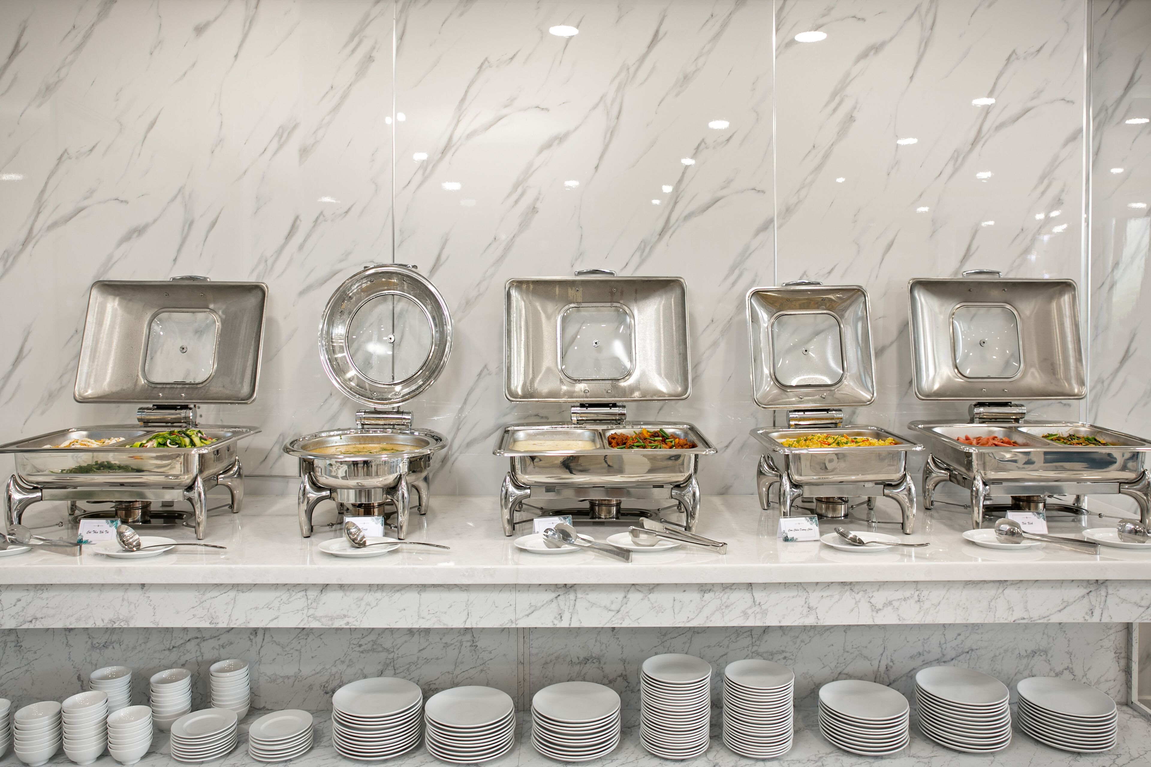 A buffet setup with multiple serving stations, each with a variety of dishes.
