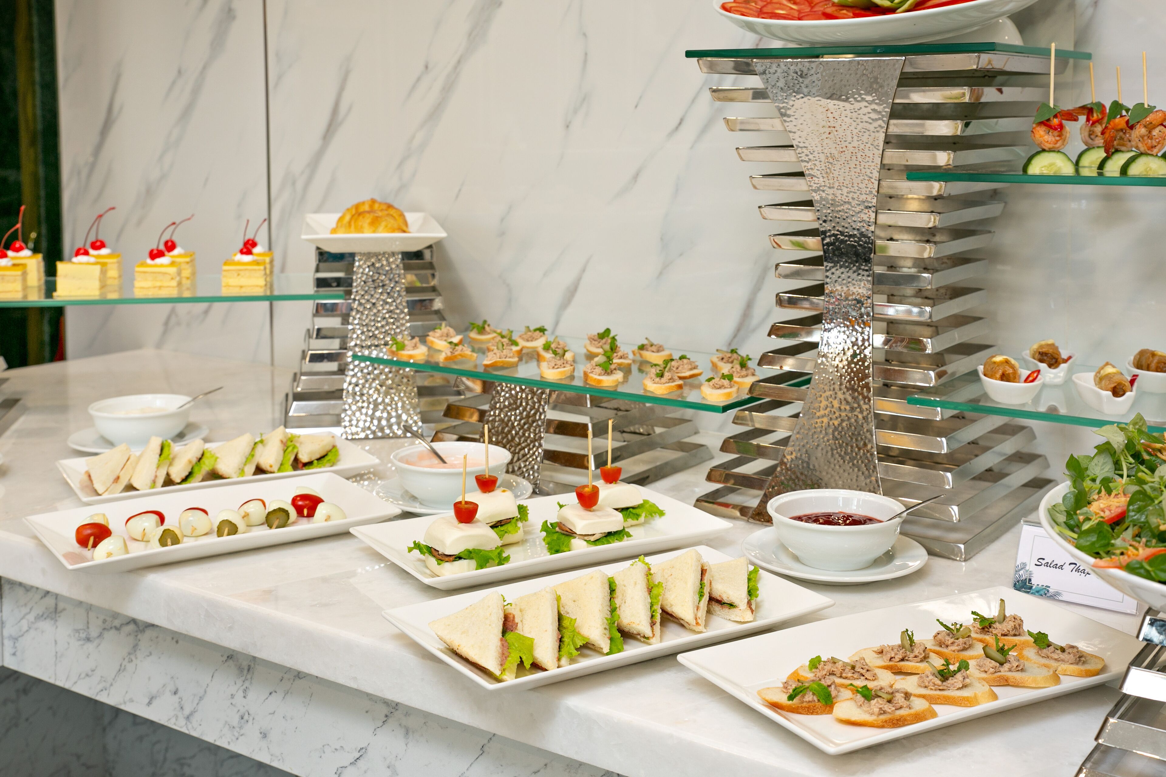 Un buffet proposant une variété de plats, notamment des sandwichs, des salades et des amuse-gueules.