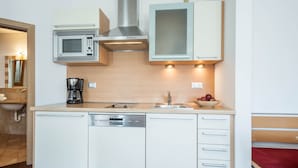 A compact kitchen with a microwave, coffee maker, and dishwasher. - Cosy Holiday Apartment "Tischlerhof - Typ C" with Wi-Fi and Mountain View (Dorf Tirol bei Meran)