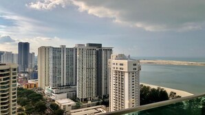 Un edificio de gran altura con varios pisos, vista al mar y otros edificios circundantes.