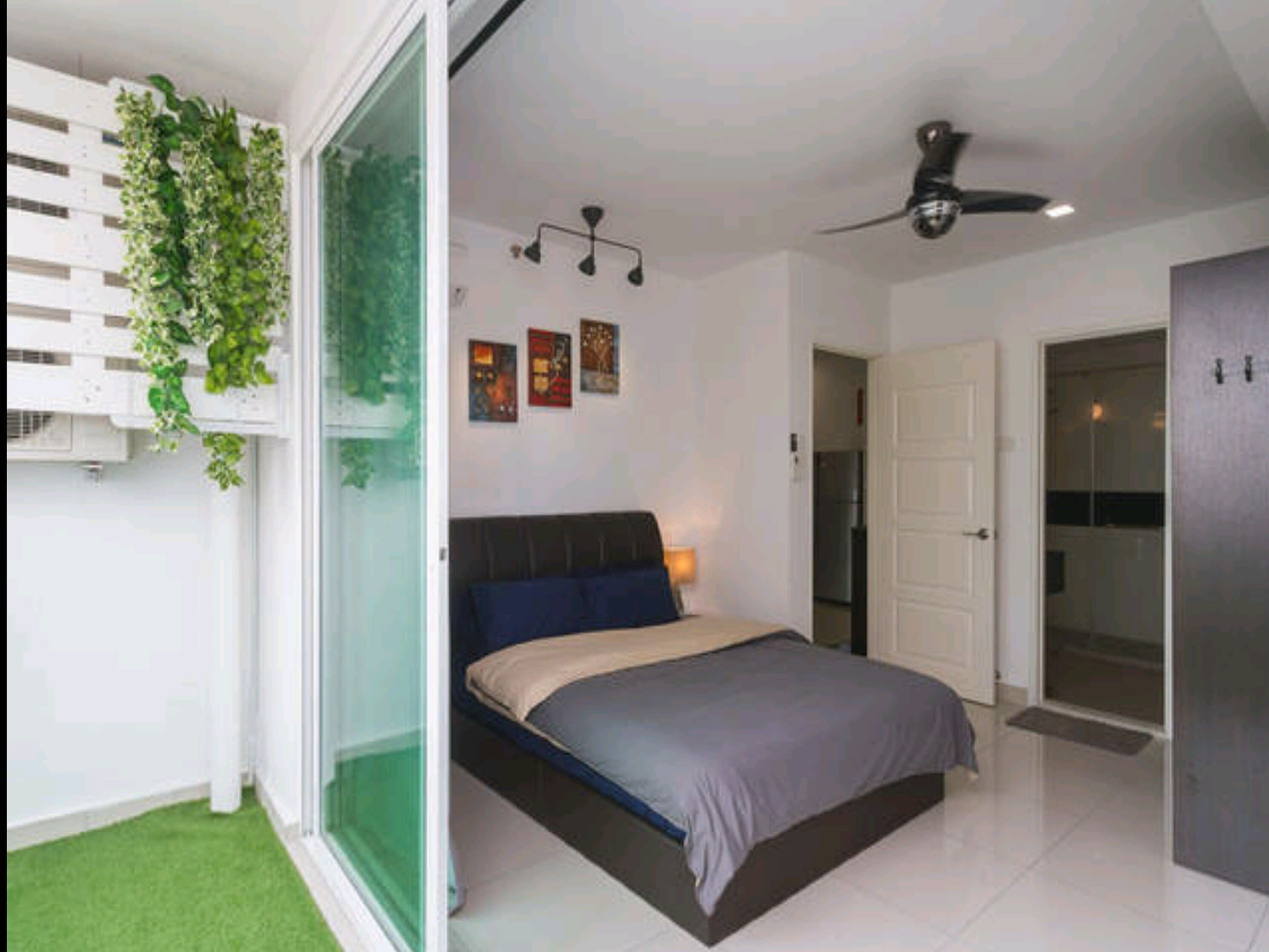Un dormitorio con cama, ventilador de techo, aire acondicionado instalado en la pared y puerta corrediza de vidrio que da a un balcón.